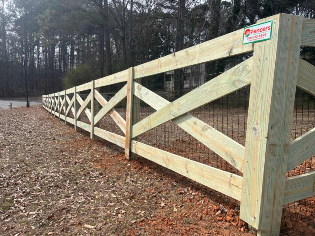 Experienced fencing contractor checking post depth and straight fence alignment