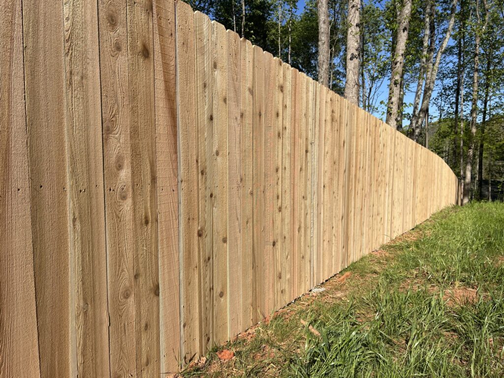 Skilled fence installer checking post depth and gate alignment with professional tools
