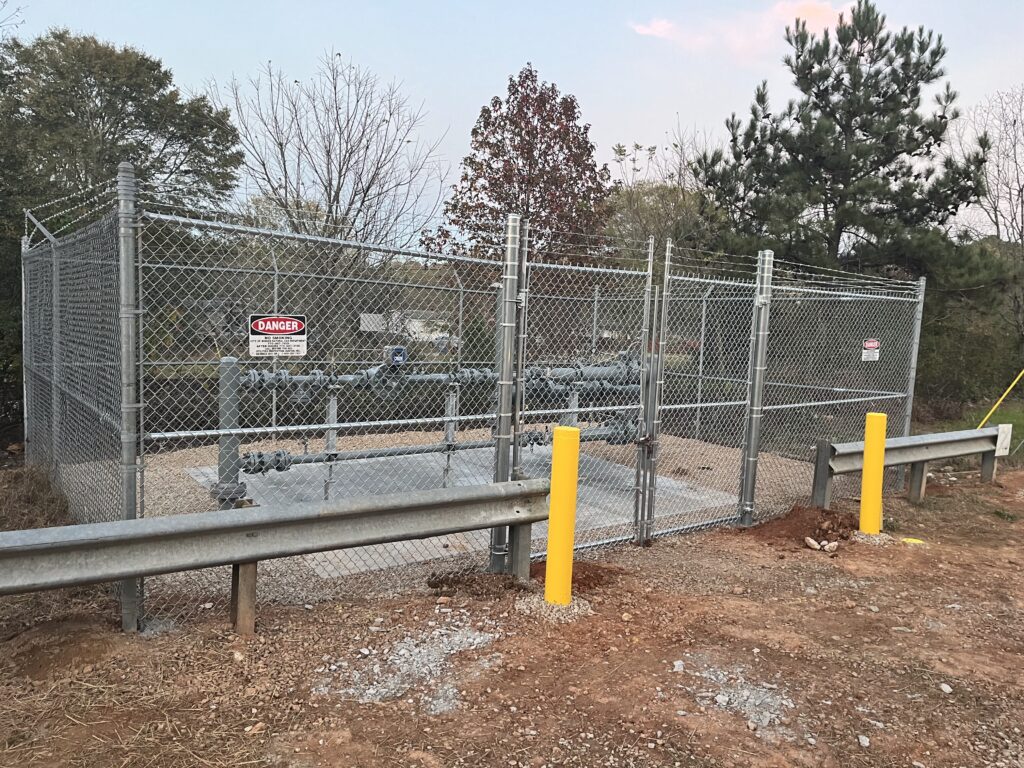 Fence professional inspecting post depth and gate swing with precision tools