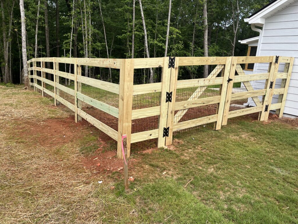 Professional fence specialist checking grade changes and post alignment on residential site