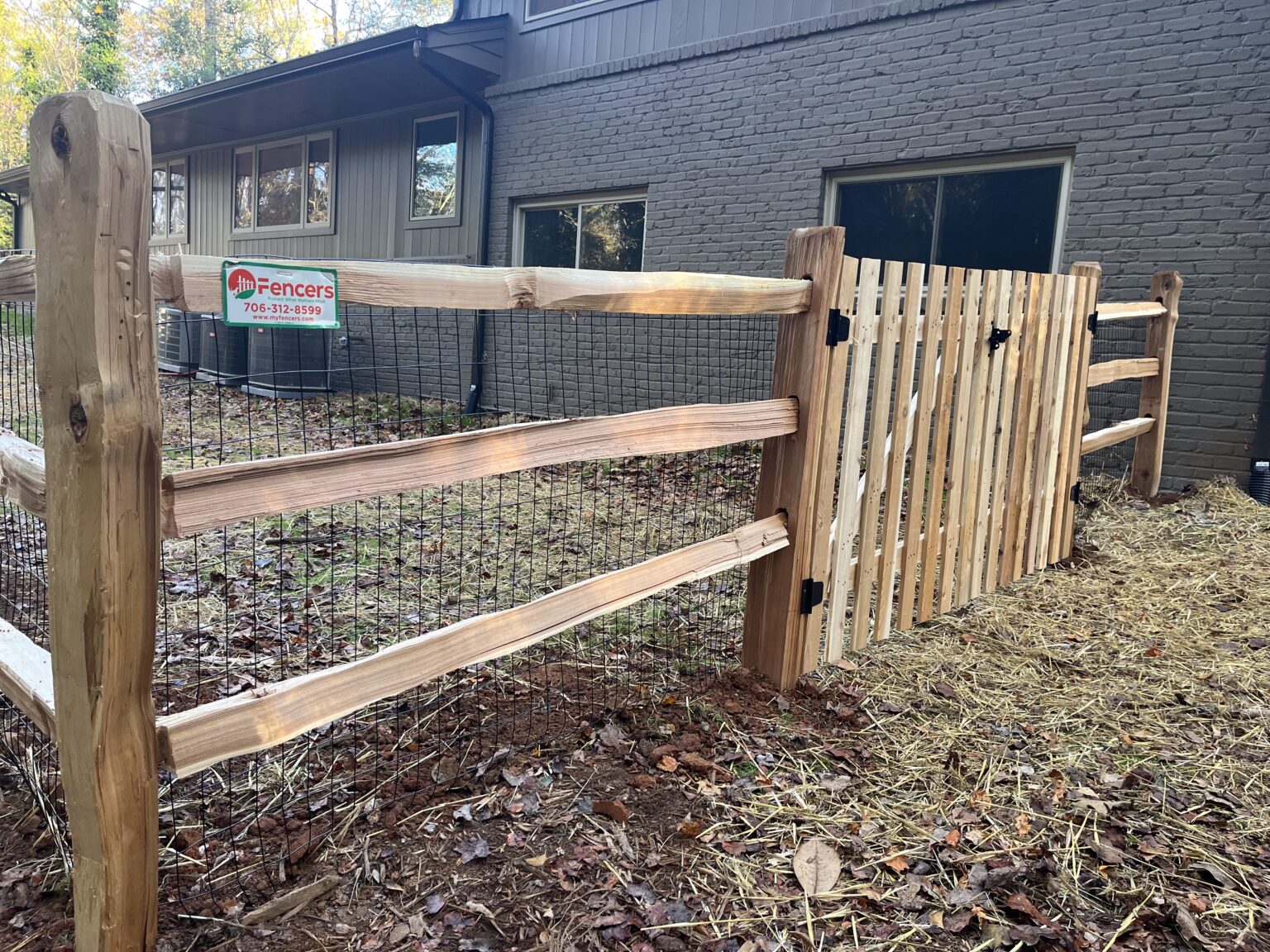 Fence installer measuring post placement and grade for clean aligned installation