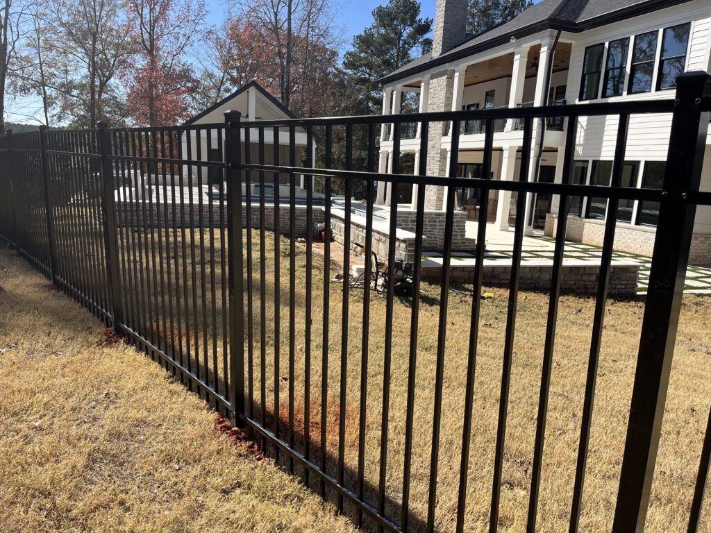 Fence professional measuring grade changes before installing posts on uneven lot