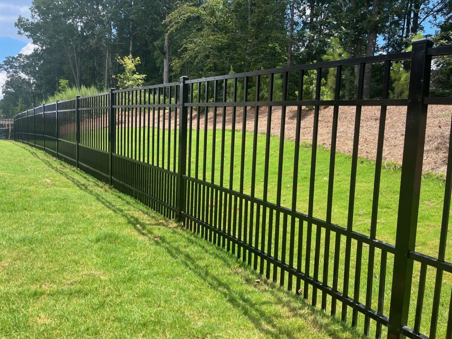 Fence installer checking post depth and straight line along residential yard