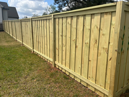 Professional Wood Fencing in Athens, GA, New privacy fence installed behind Walton County home for safer backyard and improved curb appeal, Fence crew setting straight posts along a large rural property boundary
