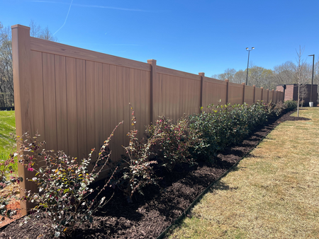 Low-Maintenance Vinyl Fence installation in Athens, GA using reinforced posts and vinyl panels, Fence installers setting posts for a new backyard privacy fence beside a driveway